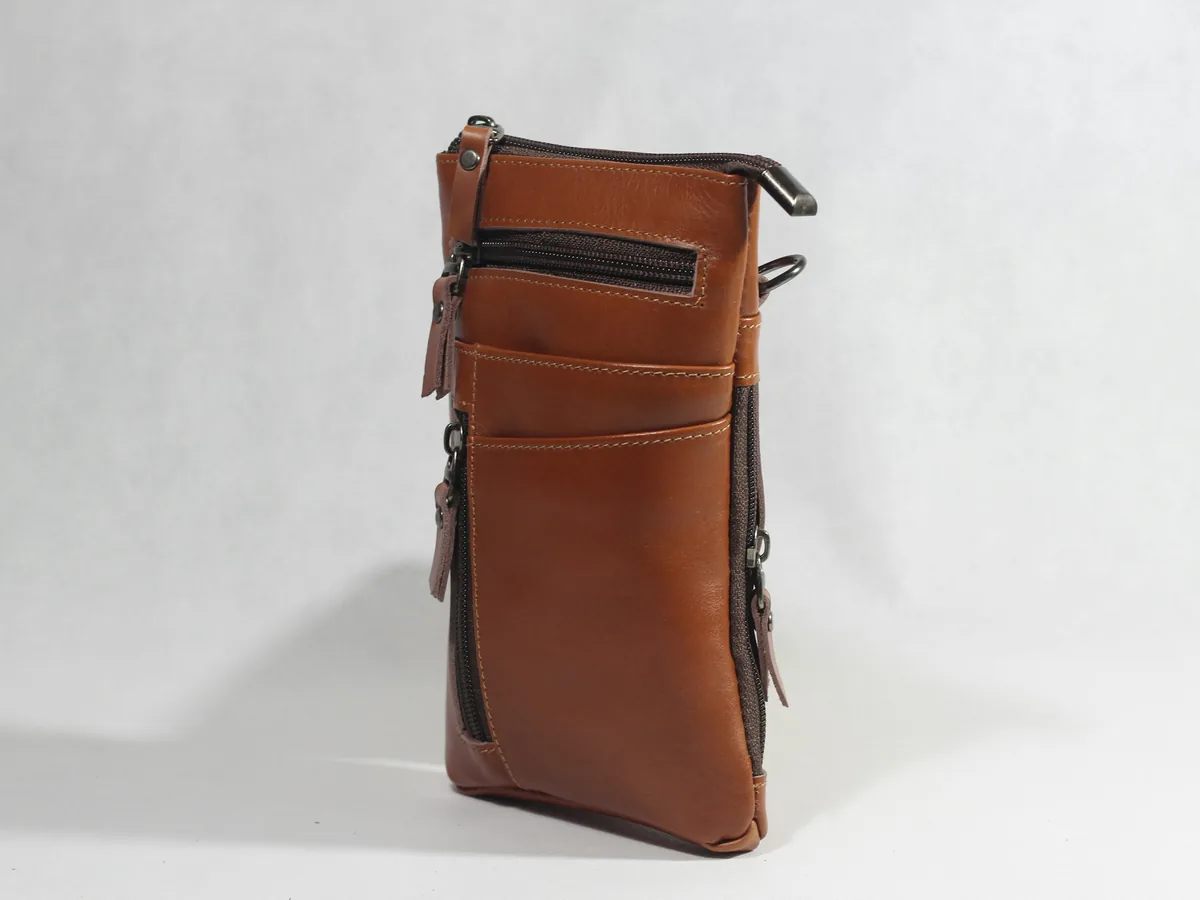 Brown leather zip bag with stitched exterior pockets on a neutral background.